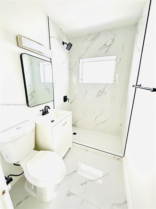 bathroom featuring tiled shower, vanity, and toilet