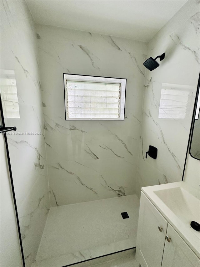 bathroom featuring a tile shower and vanity