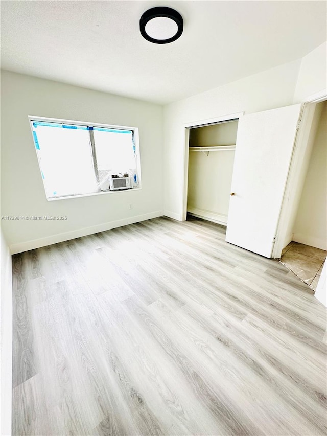 unfurnished bedroom with light hardwood / wood-style flooring and a closet