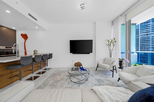 living room featuring sink and light tile patterned floors