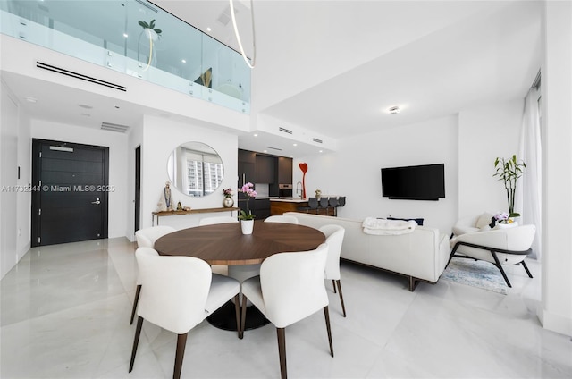 dining space featuring a towering ceiling