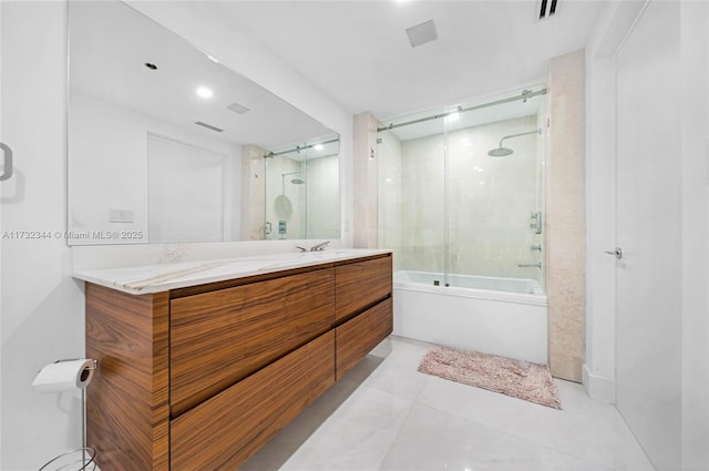 bathroom featuring vanity, tile patterned flooring, and combined bath / shower with glass door