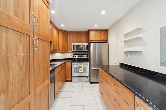 kitchen with decorative backsplash, stainless steel appliances, dark stone counters, and light tile patterned flooring