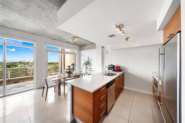 kitchen with stainless steel appliances, light tile patterned flooring, sink, and kitchen peninsula