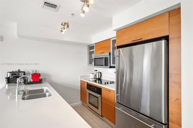 kitchen featuring appliances with stainless steel finishes, rail lighting, sink, and light tile patterned floors