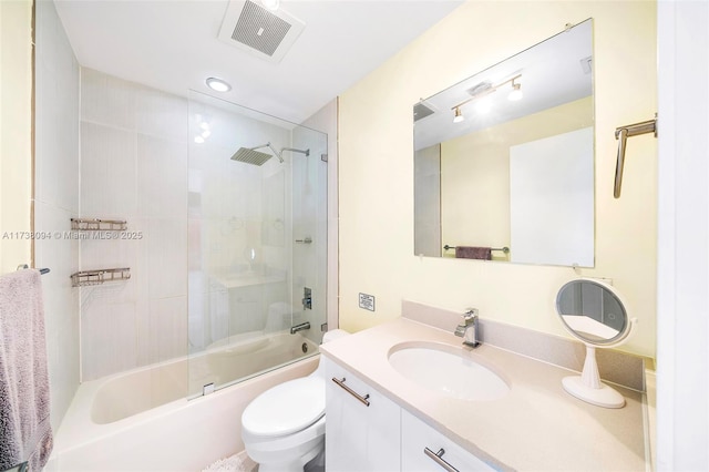 full bathroom featuring vanity, combined bath / shower with glass door, and toilet