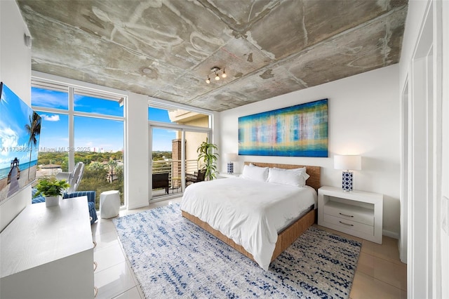 bedroom with expansive windows, light tile patterned floors, and access to outside