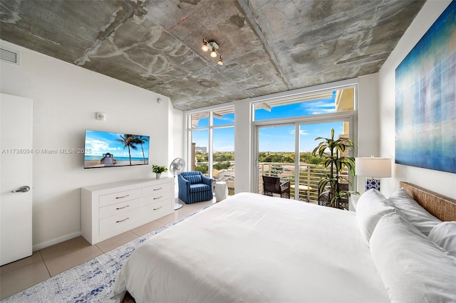 bedroom with light tile patterned floors and access to exterior