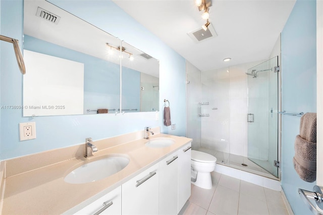 bathroom featuring vanity, a shower with shower door, tile patterned floors, and toilet