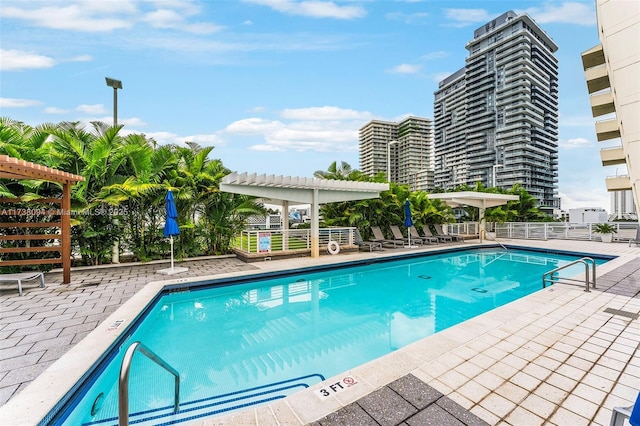 view of swimming pool featuring a pergola and a patio