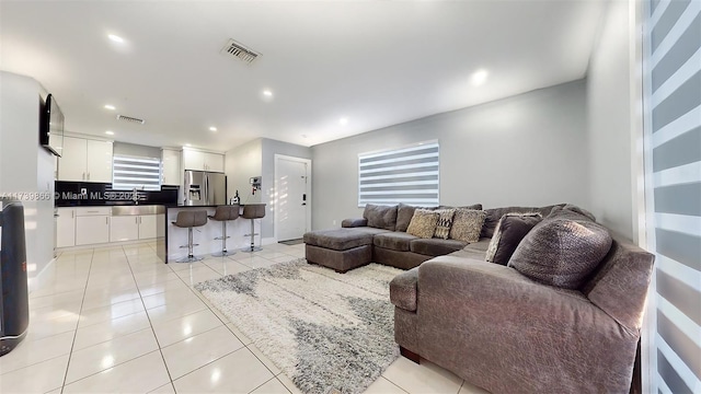 living room featuring sink and light tile patterned floors