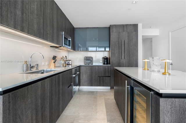 kitchen featuring wine cooler, appliances with stainless steel finishes, sink, and decorative backsplash