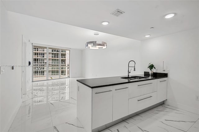 kitchen featuring sink, white cabinets, and kitchen peninsula