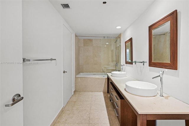 bathroom featuring tiled shower / bath combo, vanity, and tile patterned floors