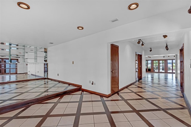 empty room featuring french doors and light tile patterned floors