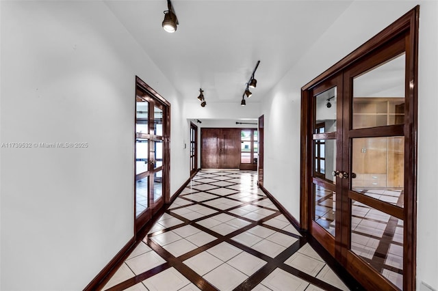 hall featuring rail lighting and french doors