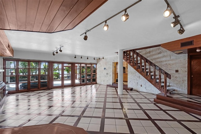 unfurnished living room featuring french doors, rail lighting, and tile patterned flooring