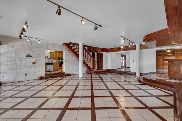 unfurnished living room featuring track lighting and tile patterned floors