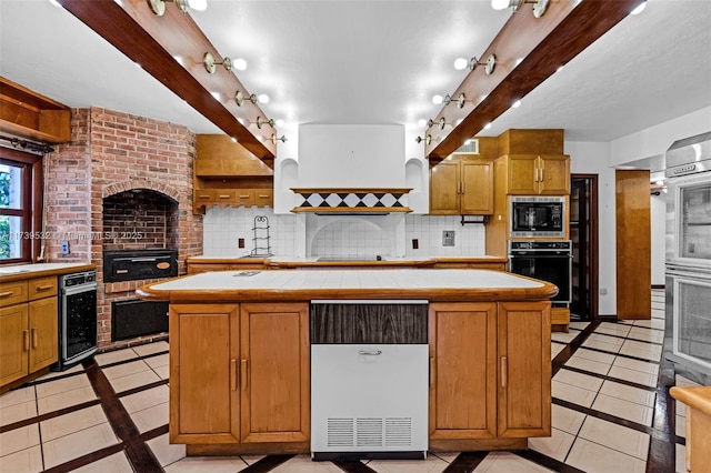 kitchen with custom exhaust hood, a center island, tile counters, and decorative backsplash