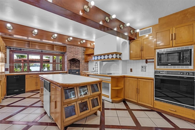 kitchen with backsplash, a center island, tile counters, black appliances, and custom range hood