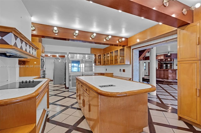 kitchen with stainless steel appliances, a center island, tile counters, and backsplash