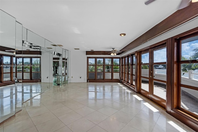 tiled empty room featuring ceiling fan and french doors