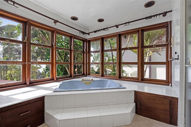 bathroom with tiled tub, a wealth of natural light, and tile patterned floors