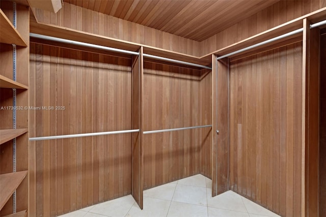 walk in closet with elevator and light tile patterned flooring