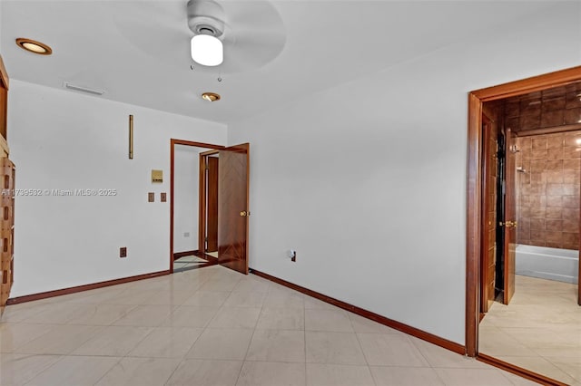 spare room with ceiling fan and light tile patterned floors