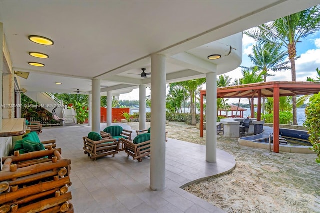 view of patio / terrace featuring a gazebo, ceiling fan, and a water view