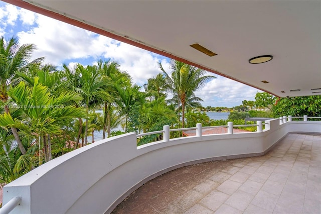 view of patio featuring a balcony and a water view