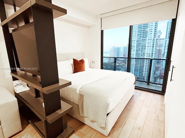 bedroom featuring floor to ceiling windows and light hardwood / wood-style flooring