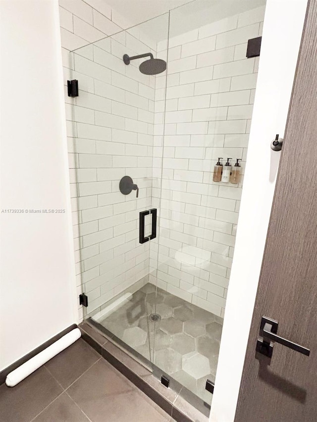 bathroom featuring tile patterned flooring and a shower with shower door