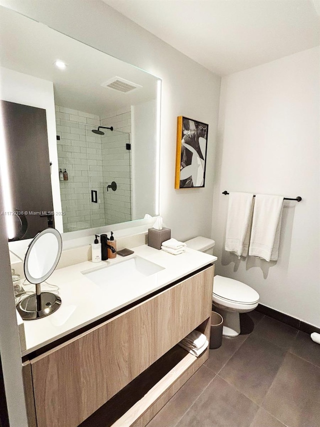 bathroom with vanity, tile patterned floors, a shower with door, and toilet