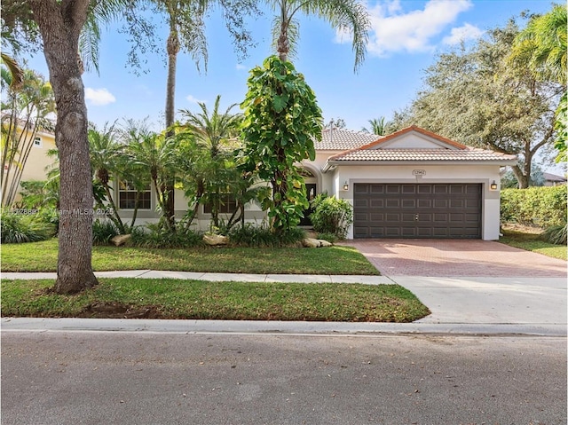 mediterranean / spanish-style house featuring a garage and a front lawn