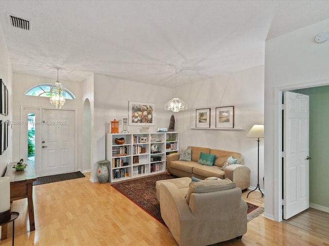 living room with an inviting chandelier and wood-type flooring