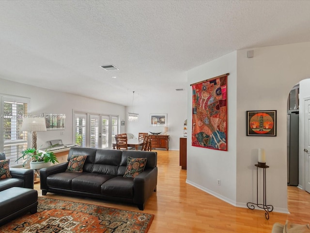 living room with light hardwood / wood-style floors and a textured ceiling