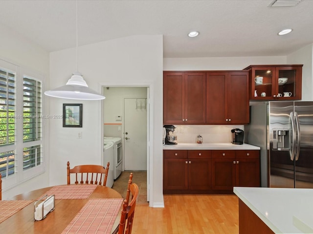 kitchen with decorative light fixtures, separate washer and dryer, decorative backsplash, light hardwood / wood-style floors, and stainless steel fridge with ice dispenser