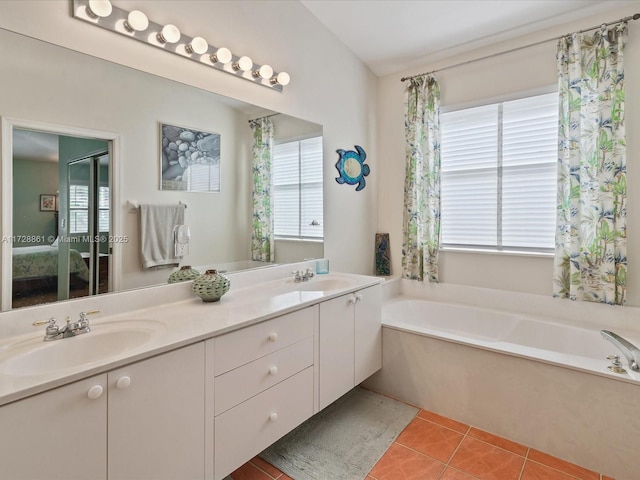 bathroom featuring vanity, tile patterned flooring, and a bathtub