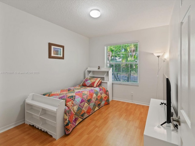 bedroom featuring wood-type flooring and a textured ceiling