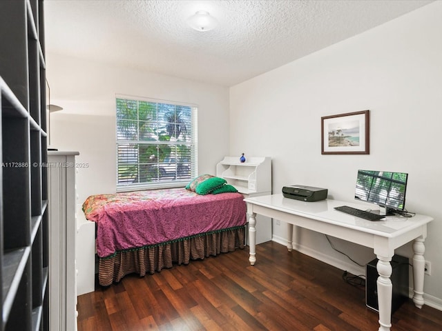 bedroom featuring dark wood-type flooring and a textured ceiling