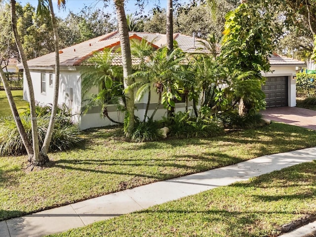 view of front of home with a garage and a front lawn