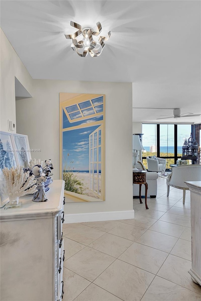 dining space featuring light tile patterned floors, a wall of windows, and baseboards