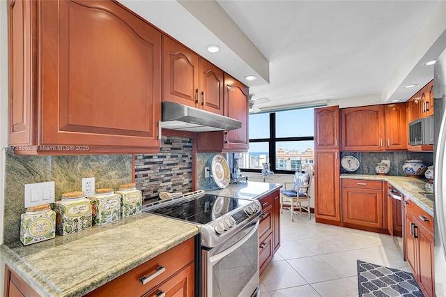 kitchen with tasteful backsplash, light tile patterned flooring, and appliances with stainless steel finishes