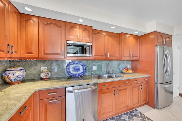 kitchen with sink, light tile patterned floors, stainless steel appliances, light stone countertops, and backsplash