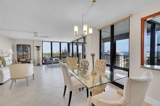 dining room with a water view, floor to ceiling windows, ceiling fan with notable chandelier, and light tile patterned floors