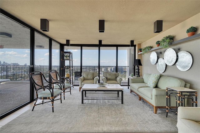 tiled living room featuring a healthy amount of sunlight, a textured ceiling, and a wall of windows