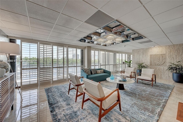 living area with a paneled ceiling and expansive windows