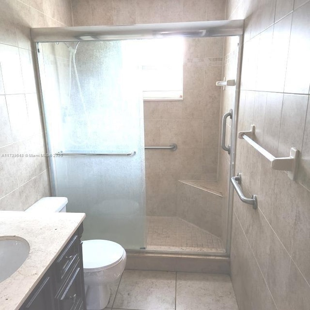 bathroom featuring vanity, toilet, a shower with shower door, and tile patterned flooring