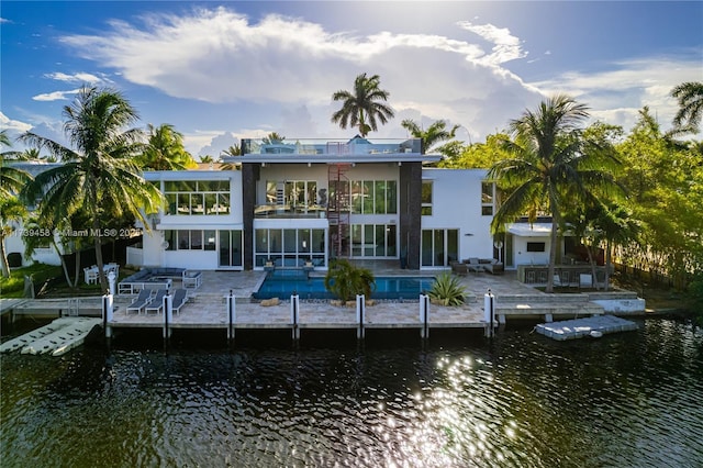 back of property featuring a patio area, a balcony, and a water view